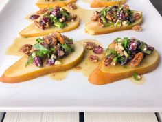 pears with walnuts and cranberries are arranged on a white platter