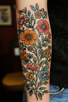 a woman's arm with flowers and leaves tattooed on the side of her body