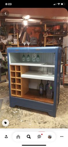 an old fashioned bar with wine glasses on it's top and shelves in the back