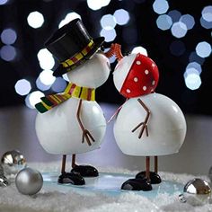 two snowmen standing next to each other in the snow