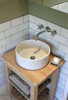 a white sink sitting on top of a wooden counter