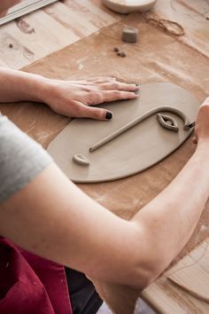 a woman is making clay on a table