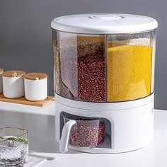 a white blender filled with lots of different types of food next to a glass of water