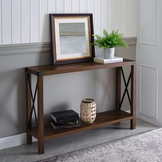 a wooden shelf with books and a plant on it next to a framed photograph in a living room