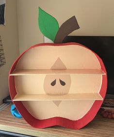 an apple shaped book shelf sitting on top of a desk