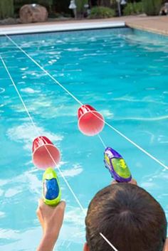 a boy is playing with water toys in the pool