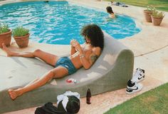 a man sitting on top of a pool next to a swimming pool