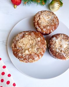 three donuts on a plate with icing and sprinkles