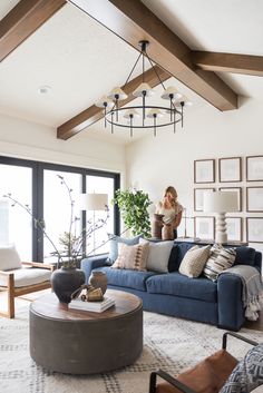 a living room with blue couches and pictures on the wall above them, along with a coffee table