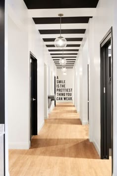 the hallway is lined with black and white striped walls, along with wood flooring