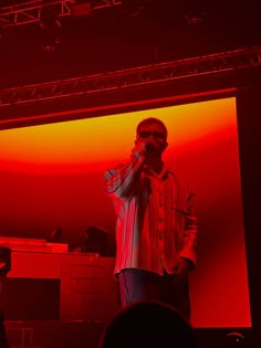 a man standing on top of a stage holding a microphone