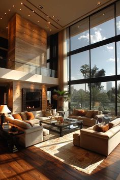 a living room filled with lots of furniture next to large windows on top of a wooden floor