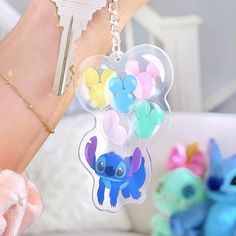 a person holding a keychain with balloons attached to it