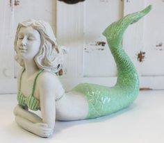 a statue of a mermaid sitting on the ground