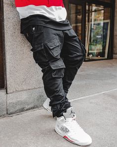 X1 Cargo Pants is designed with a custom-developed cotton and with a regular fit throughout with gusseting at the knee, numerous cargo flap pockets at side seam and front, waistband with belt loops and clip, finishing off with cargo pockets and button closure at leg opening. Instagram: @drizzydrreee Combat Style Cotton Bottoms With Pockets, Urban Straight Leg Cargo Pants, Urban Cargo Pants For Urban Adventures, Combat Cotton Cargo Pants, Combat Cotton Parachute Pants With Multiple Pockets, Urban Style Cargo Pants With Multiple Pockets, Urban Cargo Pants With Multiple Pockets For Adventures, Baggy Combat Cotton Cargo Pants, Baggy Cotton Combat Cargo Pants