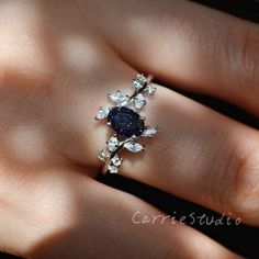 a woman's hand with a diamond and sapphire ring