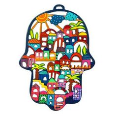 a hamsa shaped like a city with buildings and palm trees on the front, painted in bright colors