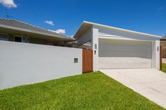 a white house with a brown door and green grass