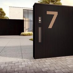 a black building with the number seven on it's door and brick walkway in front of it