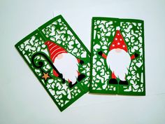 two christmas cards with santa claus on them, cut out from green paper and placed next to each other