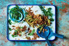 a blue tray topped with pasta and meat