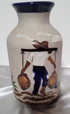 a painted vase with a man carrying two bags