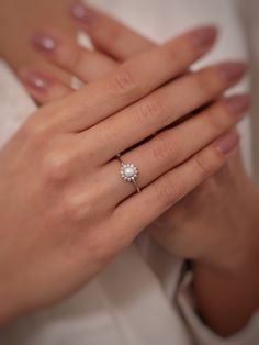 a woman's hand with a diamond ring on it