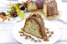 a piece of cake on a plate with nuts around it and another slice in the background