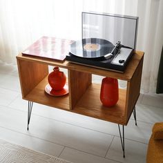 an old record player and two vases on a table