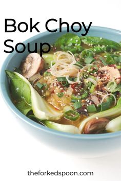 a blue bowl filled with noodles and vegetables on top of a white table next to an advertisement for ginger noodle soup