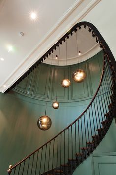 a spiral staircase with three lights hanging from it