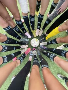 a group of people standing in a circle with their legs crossed and wearing soccer socks