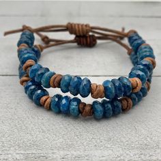 Rustic brown leather and blue Apatite gemstone stacking bracelets. The Apatite stones are faceted and have a beautiful deep blue color. These bracelets look great alone or stacked together and with other bracelets. The classic look of gemstones with modern and edgy leather. Groups of three gemstones knotted together around a leather bracelet. Finished with a sliding knot clasp. The clasp adjusts to help you get the perfect fit. Slide the leather knot over the bracelet straps to open up the brace Adjustable Blue Leather Bracelet, Adjustable Blue Leather Bracelet For Everyday, Adjustable Blue Leather Bracelets, Rustic Blue Adjustable Beaded Bracelets, Rustic Adjustable Blue Beaded Bracelet, Rustic Blue Adjustable Beaded Bracelet, Adjustable Hand Wrapped Blue Leather Bracelet, Blue Leather Bracelet As A Gift, Rustic Adjustable Blue Bracelets