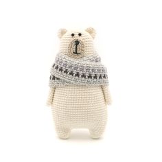 a knitted teddy bear with a scarf around it's neck on a white background