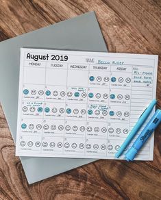 a calendar and pen sitting on top of a wooden table next to some papers with the dates