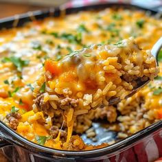 a spoonful of mexican rice casserole with ground beef and cheese on it