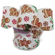 a roll of white christmas ribbon with ginger cookies and candy canes on it's side