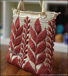 a red and white purse sitting on top of a wooden table