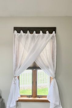 a window with white curtains hanging over it