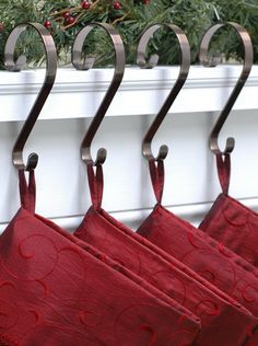 three red towels hanging from hooks on a white rail