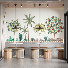 the wall is decorated with tropical trees and plants, along with stools for seating