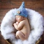 a newborn baby wearing a blue hat in a basket