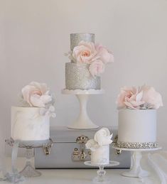 three different types of wedding cakes on top of a white cake stand with pink flowers