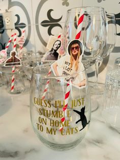 there are many wine glasses that have pictures on the glass and straws in them