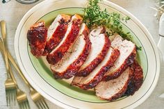 sliced pork on a plate with garnish and silverware