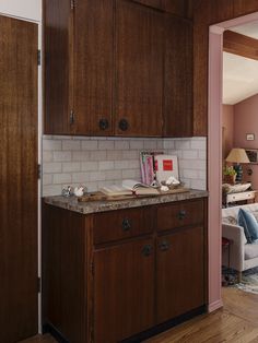 an open door leading to a living room filled with furniture and books on top of a counter