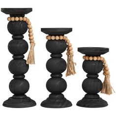 three black candlesticks with wooden beads and tassels