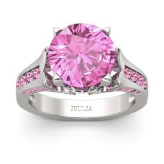 a pink diamond ring set in white gold with pink diamonds on the band and side stones