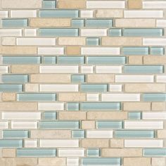 a white and blue tile wall with some light colored tiles on the bottom half of it