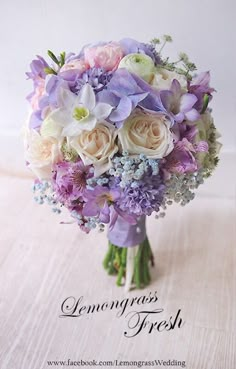 a bridal bouquet with lavenders and white roses on a linen tablecloth that says lemongrass fresh